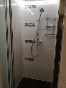 y baño con ducha y azulejos blancos y negros. en Apartament Złoty w Centrum Miasta en Częstochowa