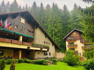 a building in the middle of a field with trees at Boutique Hotel Casa Emil in Poiana Brasov +5 photos