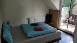 1 dormitorio con 1 cama con manta roja y ventana en Ferienwohnung im Spreewald in idyllischer Alleinlage, en Werben
