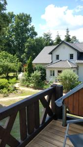 una terraza de madera con un banco y una casa en Ferienwohnung im Spreewald in idyllischer Alleinlage, en Werben