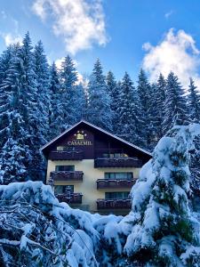 a building in the snow with snow covered trees at Boutique Hotel Casa Emil in Poiana Brasov
