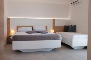 a white bedroom with two beds in a room at Apartments Villa Agatha in Sveti Filip i Jakov