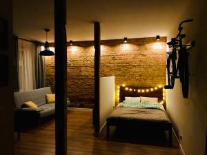a bedroom with a bed and a brick wall with lights at Apartament Sienkiewicza in Głuszyca