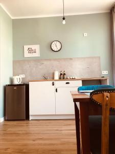 a kitchen with a refrigerator and a clock on the wall at Apartament Sienkiewicza in Głuszyca