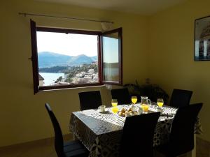 a dining room table with wine glasses and a window at Apartments Gracia & Toni in Trogir