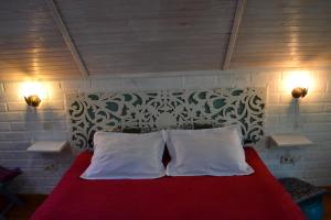 1 dormitorio con 1 cama roja y 2 almohadas blancas en Romantic Guest House, en Kamianets-Podilskyi