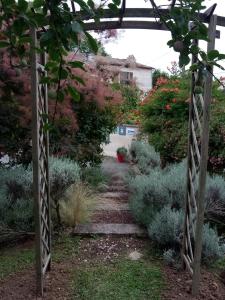 un jardin avec une tonnelle et un sentier dans l'établissement Les gîtes du veau d'or, à Ozillac