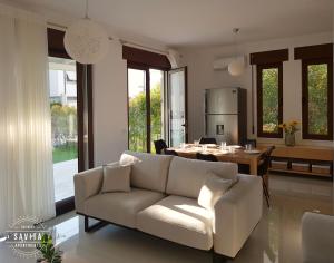 ein Wohnzimmer mit einem Sofa und einem Tisch in der Unterkunft Gjiri i Lalzit - Vila Savita - Perla Resort in Durrës
