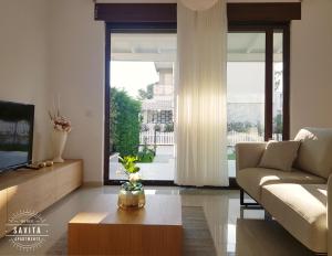 ein Wohnzimmer mit einem Sofa und einem Couchtisch in der Unterkunft Gjiri i Lalzit - Vila Savita - Perla Resort in Durrës