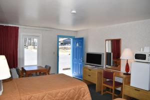 Habitación de hotel con cama y puerta azul en POCONO NIGHT LODGE, en Bartonsville