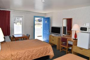 Pokój hotelowy z sypialnią z łóżkiem i telewizorem w obiekcie POCONO NIGHT LODGE w mieście Bartonsville