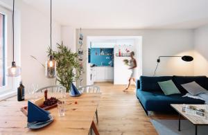 ein Wohnzimmer mit einem blauen Sofa und einem Tisch in der Unterkunft Rotes Haus Bregenz See Wohnung in Bregenz