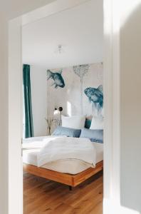 Rotes Haus Bregenz See Wohnung في بريغنز: غرفة نوم مع سرير ووسائد زرقاء وبيضاء