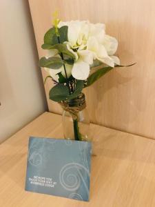 a vase with white flowers on a table next to a card at Riverfield Lodge in Athboy