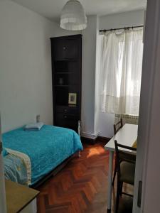 ア・コルーニャにあるPiso Playa y Centro A Coruña 6 Personasのベッドルーム1室(ベッド1台、テーブル、椅子付)