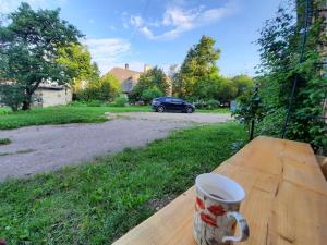 a cup of coffee sitting on a wooden table at Vaļņu Ielas Apartments in Cēsis