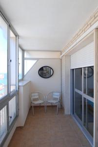 een kamer met 2 stoelen, een tafel en ramen bij don juan in Fuengirola
