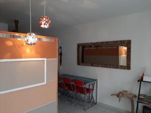 cocina con 2 sillas rojas y espejo en appartement Callebasse, en Cayenne