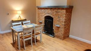 a dining room with a table and a brick fireplace at Riverside Marina Apartments in Lanesborough