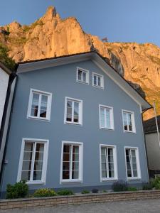 a white house with a cliff in the background at Appartement Weiss in Essing