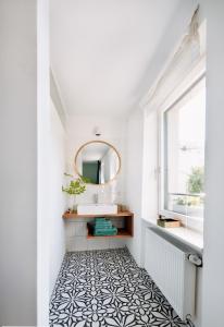 y baño con espejo y suelo de baldosa blanco y negro. en Rotes Haus Bregenz Wald Wohnung, en Bregenz