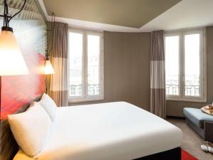 a bedroom with a large white bed and windows at ibis Bordeaux Centre Gare Saint Jean Euratlantique in Bordeaux