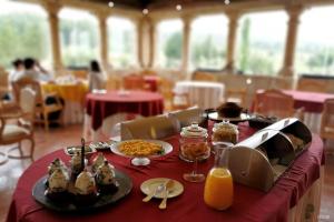 a table with plates of food on a red table cloth at Hospedaria do Convento d'Aguiar- Turismo de Habitacao in Figueira de Castelo Rodrigo