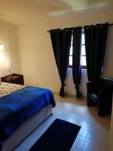 - une chambre avec un lit et une fenêtre avec des rideaux noirs dans l'établissement Villa Gwendolin, à Portimão