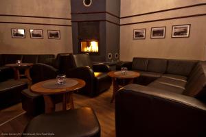 a restaurant with couches and tables and a fireplace at Arctic Inn in Gratangen