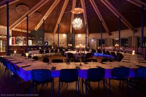 a banquet hall with tables and chairs and a chandelier at Arctic Inn in Gratangen +21 photos