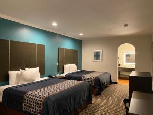 a hotel room with two beds in a room at Regency Inn & Suites- NW Houston in Houston