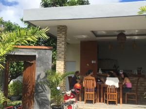 a group of people sitting at a table in a house at Arjuna Uluwatu Guest House in Uluwatu