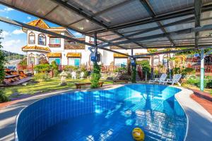 a large swimming pool in front of a building at Red Praha Pension in Geoje 