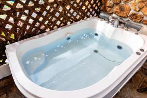 a jacuzzi bathtub in a wicker at Red Praha Pension in Geoje 