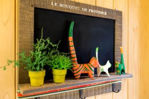 a shelf with three plants and a cat on it at Red Praha Pension in Geoje