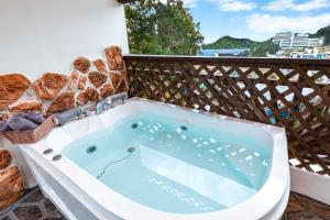 a jacuzzi tub on a balcony with bread at Red Praha Pension in Geoje 