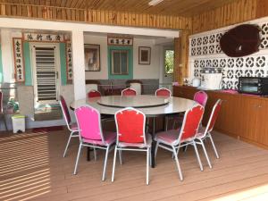 a dining room with a table and pink chairs at Nantang No. 1 in Lieyu