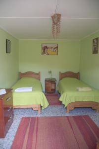 a bedroom with two beds and a dresser and a table at Hostal Sonchek in San Pedro de Atacama