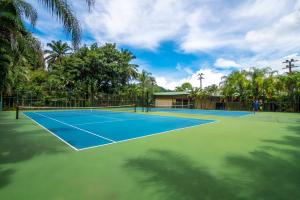 two people playing tennis on a tennis court at Hotel Casa Roland Golfito Resort in Golfito