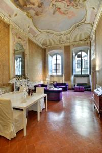 a large room with a ceiling with a table and chairs at Palazzo Tolomei - Residenza D'Epoca in Florence