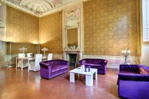 sala de estar con muebles de color púrpura y chimenea en Palazzo Tolomei - Residenza D'Epoca, en Florencia