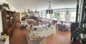 Habitación grande con mesas y sillas en un restaurante en hotel Bologna, en Fanano