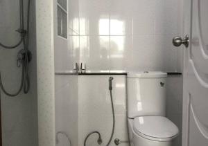 La salle de bains blanche est pourvue d'une douche et de toilettes. dans l'établissement KM Condo, à Langu