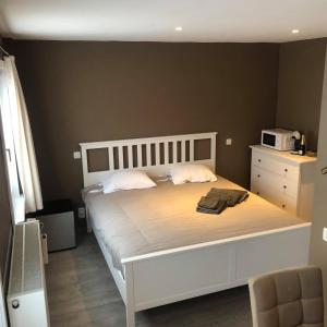 1 dormitorio con 1 cama blanca y microondas. en Break@Bruges, en Brujas