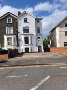 uma casa branca sentada ao lado de uma rua em Clarence Heights em Newport