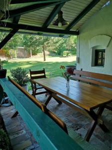 een houten tafel in een patio met een bank bij Nyugalomsziget in Kötcse