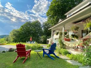 Una donna seduta su una sedia in un cortile di Artful Lodging & Retreats a Montpelier