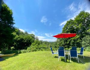 a table with chairs and an umbrella on a field at Artful Lodging & Retreats in Montpelier