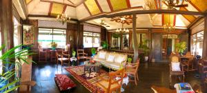 ein Wohnzimmer mit einem Sofa, Tischen und Stühlen in der Unterkunft Posada La Patriciana in Taal