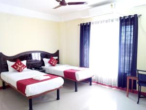 a bedroom with two beds and a window at HOTEL NILADRII GALAXY in Siliguri